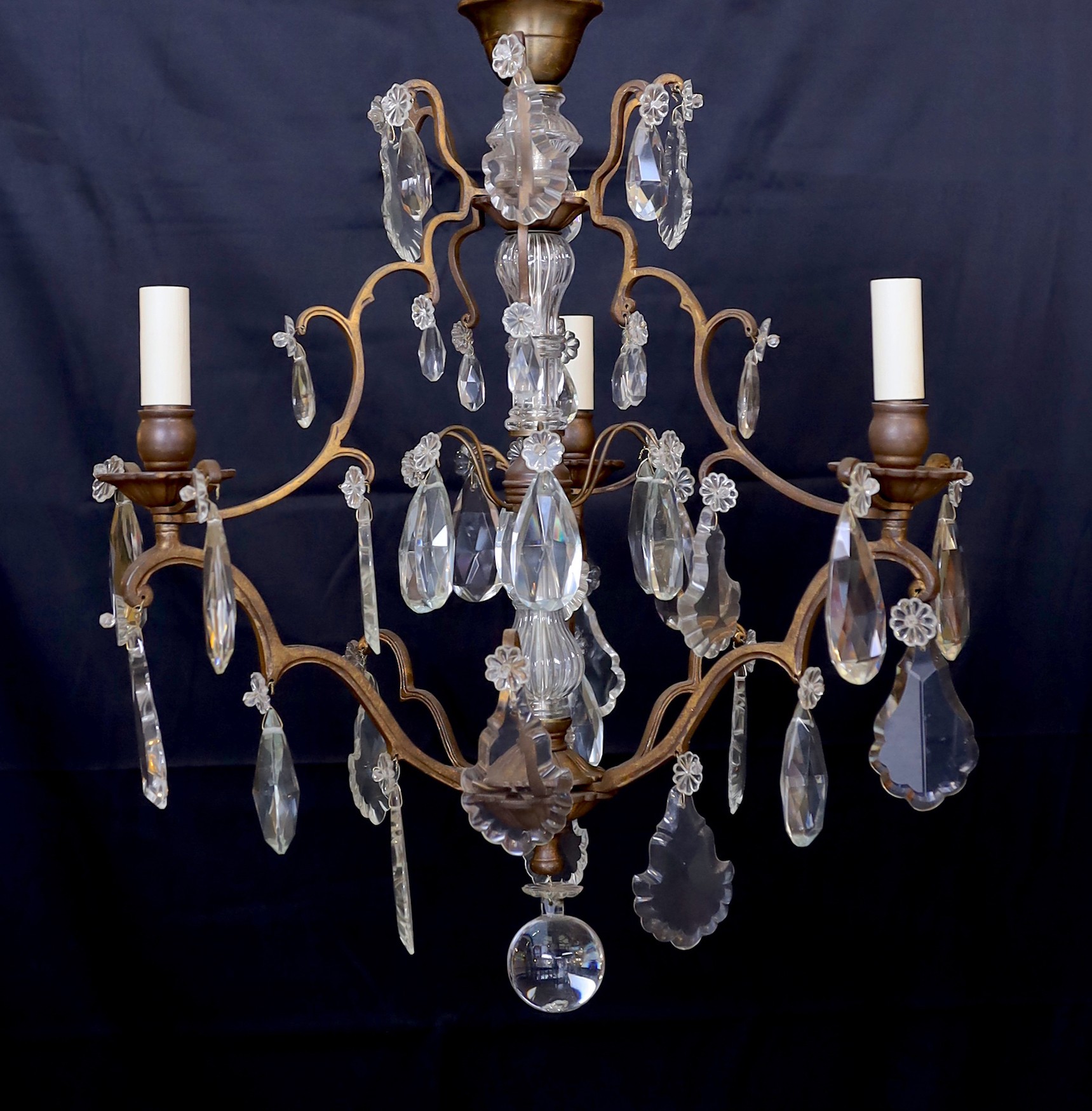 An early 20th century French bronze and cut glass three light chandelier, hung with tear shaped and faceted drops, height 64cm. width 50cm